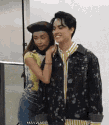a man and a woman are posing for a picture . the woman is wearing a beret .