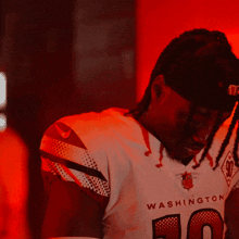 a man wearing a washington football jersey with the number 20 on it