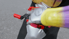 a person in a costume is holding a yellow and purple object