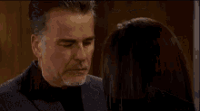 a man and a woman are looking at each other in a room .