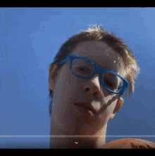 a young boy wearing blue glasses looks at the camera
