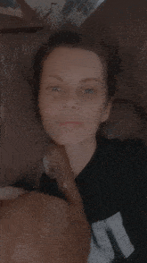 a woman laying on a couch wearing a black shirt that says ' it ' on it
