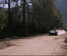 a person driving a cart down a dirt road