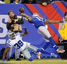 a football player with the number 39 on his jersey is trying to catch the ball