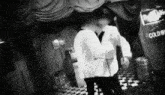 a black and white photo of two men in a room with a sign that says cold beverage