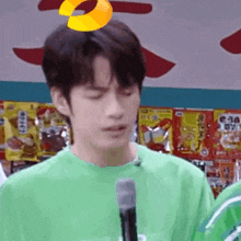 a man in a green shirt is holding a microphone in front of a store .