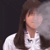 a woman with her eyes closed is wearing a white jacket
