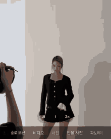 a person is taking a picture of a woman in a black outfit
