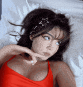 a woman in a red top is laying on a bed