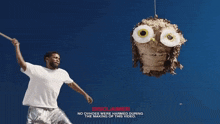 a man is holding a piñata in the shape of an owl and says disclaimer