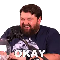 a man sitting in front of a microphone with the word okay written on his face