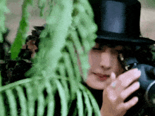 a woman in a top hat is taking a picture