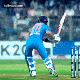a cricket player is swinging a bat at a ball during a game .