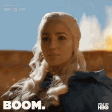 a woman with blonde hair is standing in front of a fire and the word boom is above her