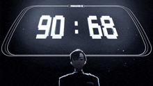 a man is standing in front of a clock that says 90.68