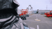 a person is standing in a parking lot with a stack of pallets on the side of the road