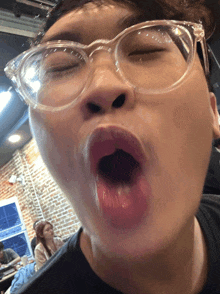 a man wearing glasses is making a funny face