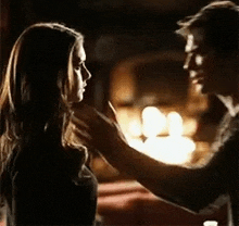 a man and a woman are standing next to each other and touching each other 's faces .