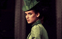 a woman wearing a green top hat and a green coat