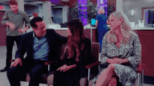 a man in a suit sits next to a woman in a chair