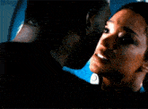 a man and a woman are kissing in front of a window