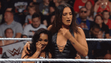 two women in a wrestling ring with the word win on the bottom right