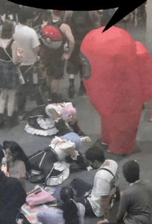 a group of people laying on the floor with a red among us costume