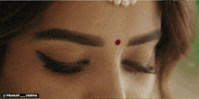 a close up of a woman 's face with a red dot on her forehead that says pranay_varma
