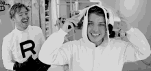 a black and white photo of a man wearing a dog costume and a hoodie .
