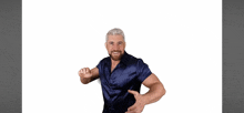 a man in a blue satin shirt is dancing