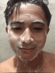 a man with soap on his face is smiling for the camera