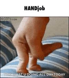 a person 's hand is holding a baby 's foot while walking on a bed .