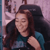 a woman is smiling while sitting in a gaming chair with a xlr logo on it