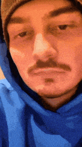 a man with a beard wearing a blue hoodie and a beanie