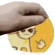 a close up of a person holding a donut with a cartoon cat on it .