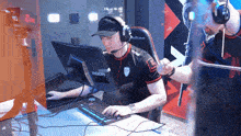 a man wearing headphones sits in front of a monitor that says aocn