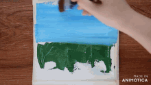 a person is painting a picture of a blue sky and a green field