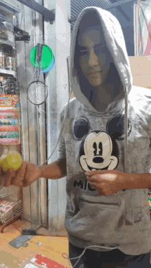 a young man wearing a mickey mouse hoodie