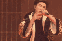 a woman singing into a microphone with the words noonapurple visible in the background
