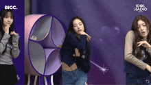 three girls are dancing in front of a bigc logo