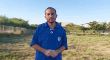 a man wearing a blue shirt with a skull on the front