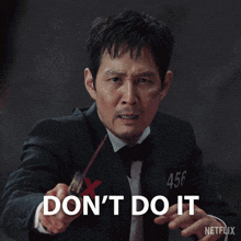 a man in a tuxedo is holding a stick and says " don 't do it "
