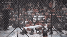 two wrestlers in a cage with the hashtag #gcwwar on the bottom right