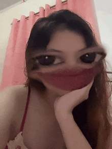 a woman with her hand on her chin looks at the camera