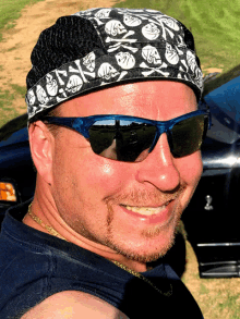 a man wearing sunglasses and a hat with skulls and crossbones on it