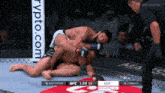 two men wrestling in a boxing ring with a crypto.com banner in the background
