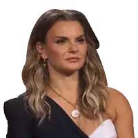 a woman wearing a black one shoulder top and a necklace with a coin on it