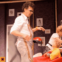a man and a woman are cutting a child 's hair in a room with pictures on the wall