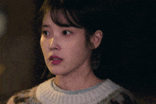 a close up of a woman wearing a sweater