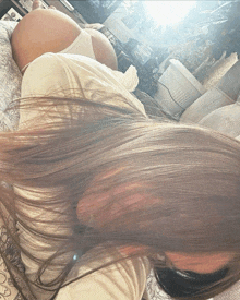 a woman with long hair is laying on a bed with her hair blowing in the wind